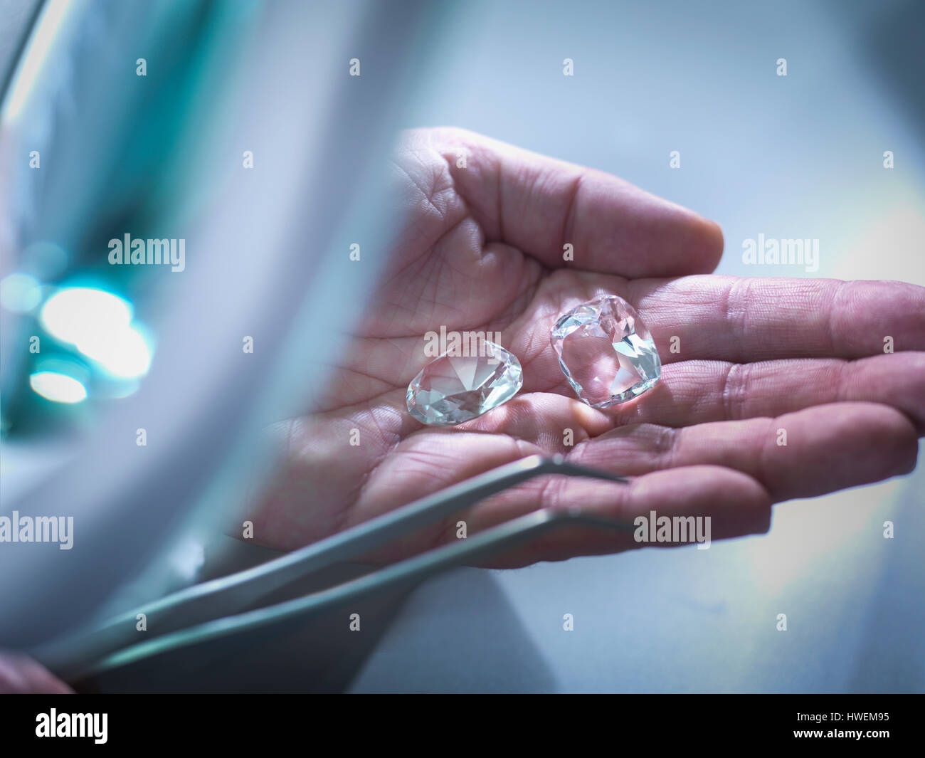Il gioielliere della replica di ispezione di diamanti in mano Foto Stock