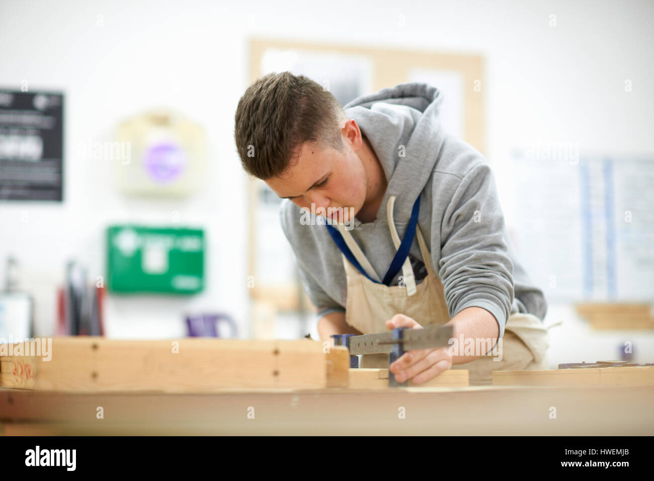 Un adolescente di sesso maschile di falegnameria di regolazione dello studente morsetto di legno nel collegio di officina Foto Stock