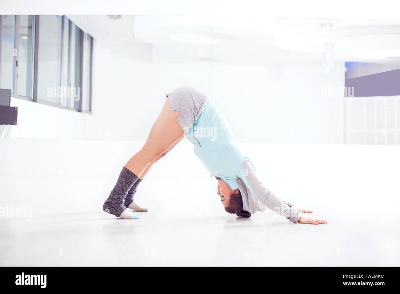 Ritratto di giovane donna ballerina la pratica in studio di ballo, la flessione in avanti Foto Stock