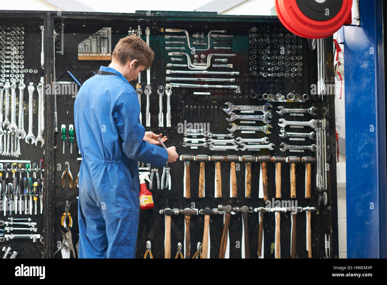 College studente meccanico selezionando la chiave dal garage di riparazione tool kit Foto Stock