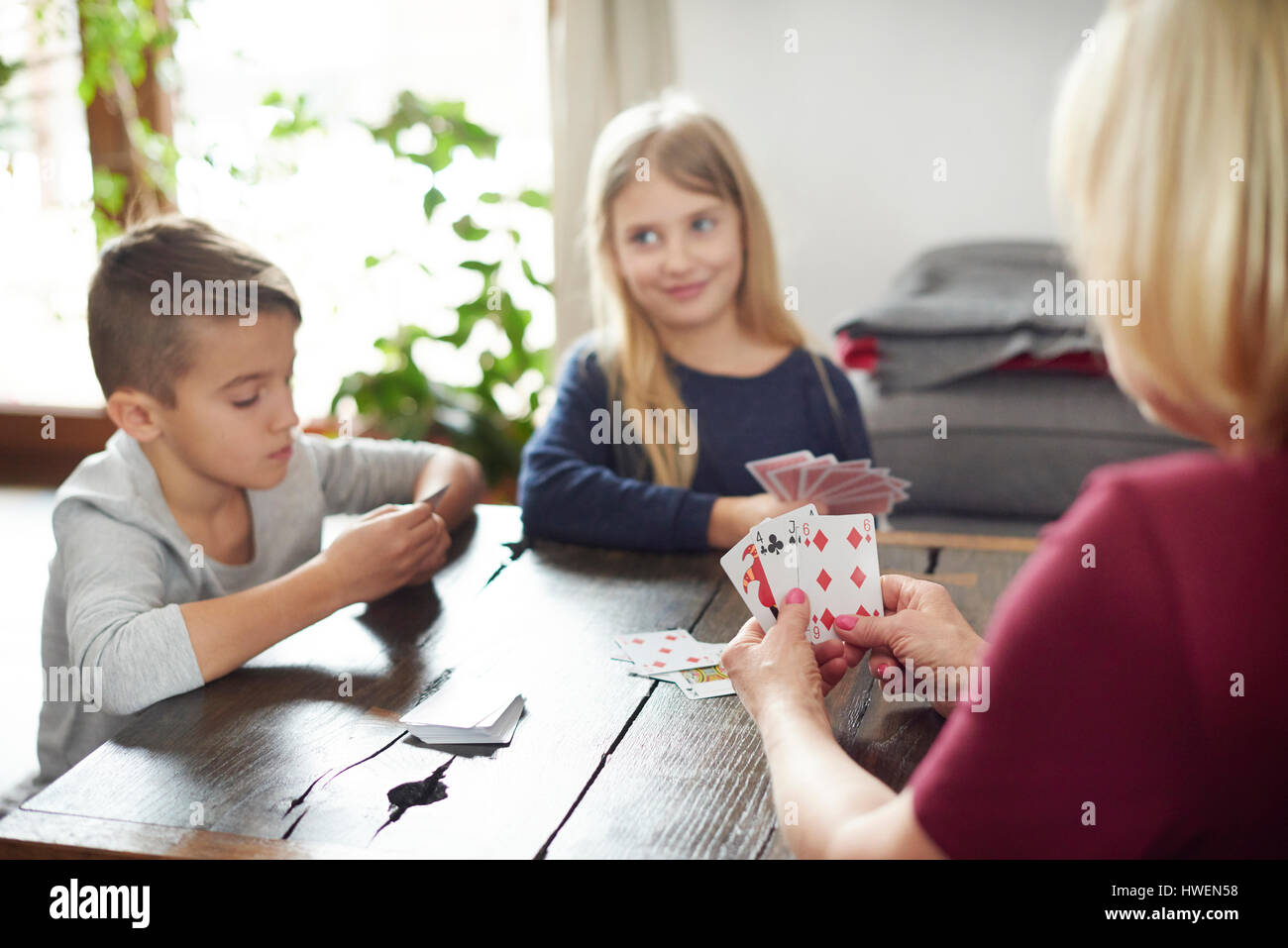 Nonna e nipoti giocando a carte a casa Foto Stock