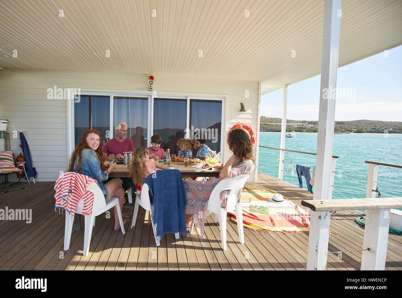 Famiglia riunita a tavola in houseboat sun deck, Kraalbaai, Sud Africa Foto Stock