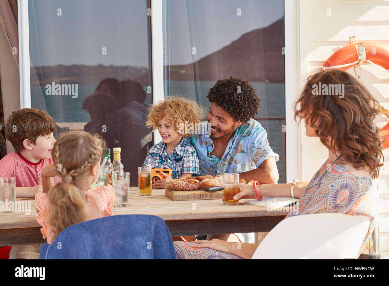 Famiglia riunita a tavola in houseboat sun deck, Kraalbaai, Sud Africa Foto Stock