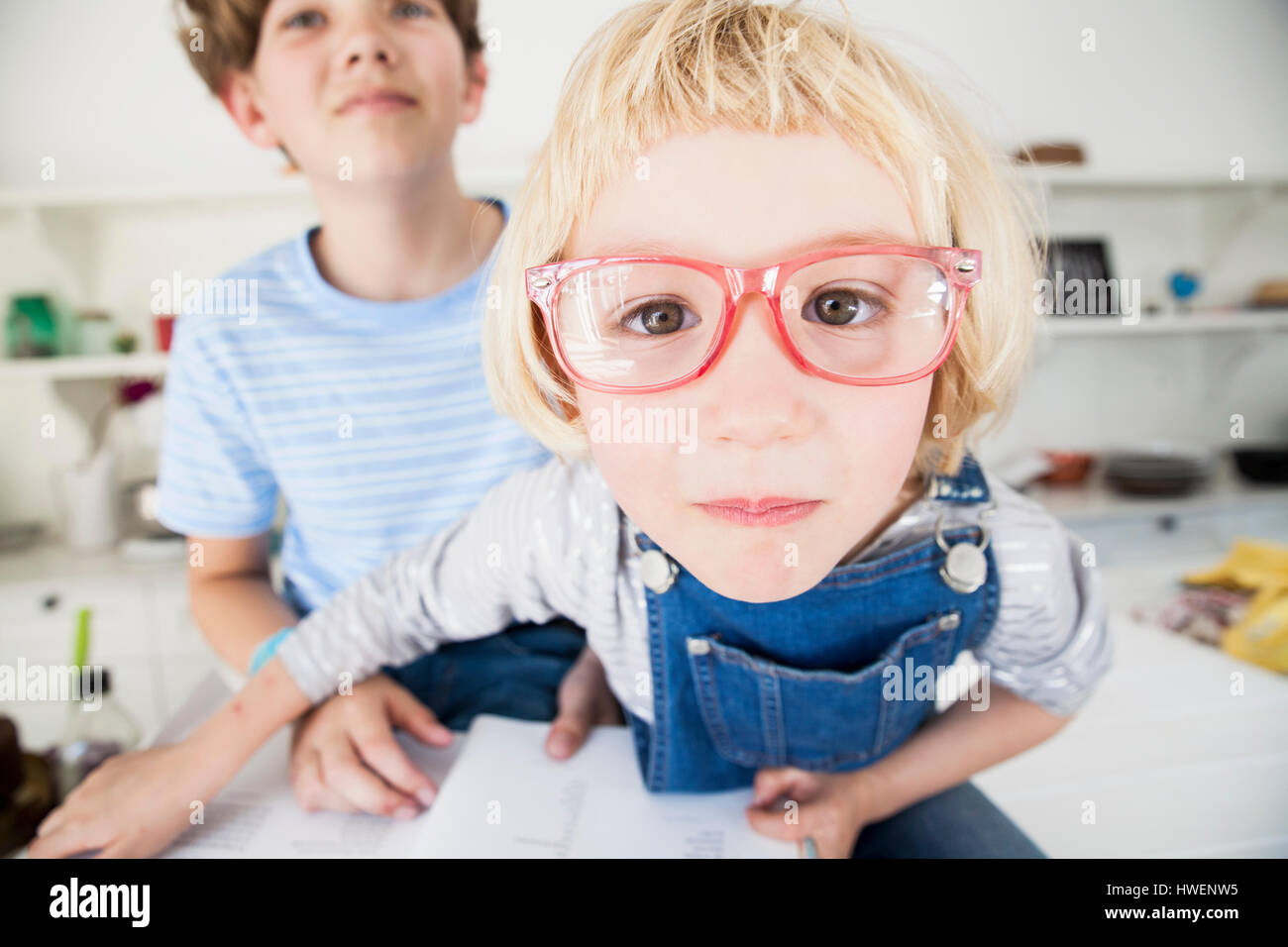 Ritratto di Cute girl in occhiali con il fratello in cucina Foto Stock
