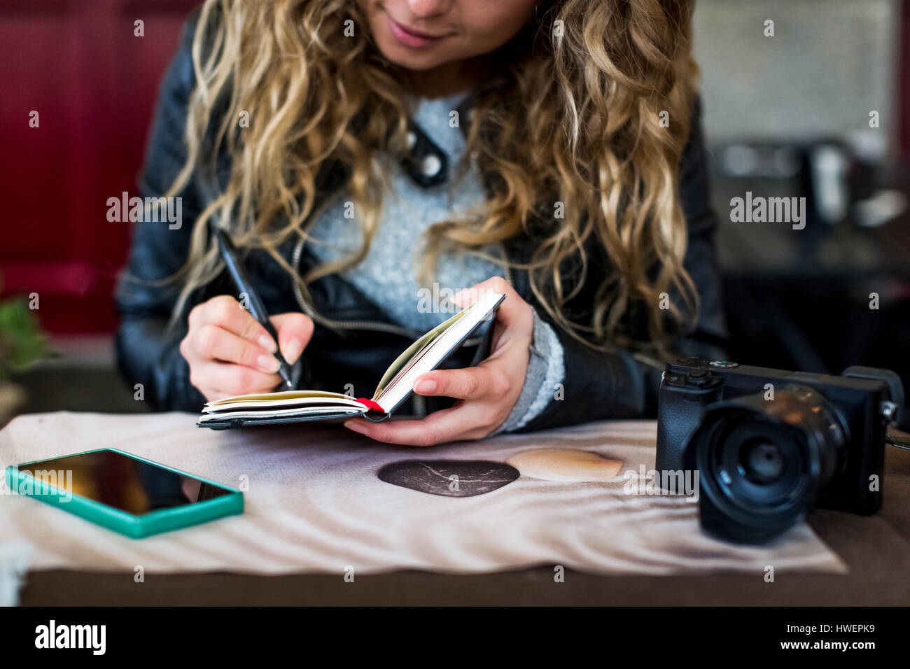 Donna al cafe iscritto nel notebook Foto Stock