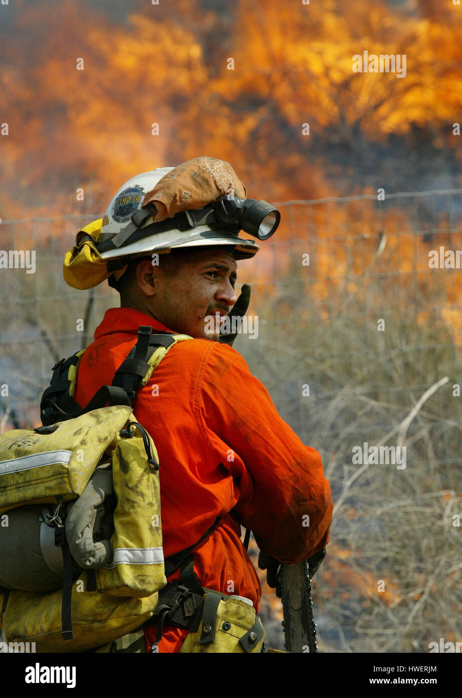 Il pompiere Oscar Rodriguez di San Diego, si spegne dal calore di un fuoco a spazzola a Temecula, California, il 4 maggio 2004. Il clima secco e caldo recente ha reso le aree della California meridionale vulnerabili agli incendi che hanno distrutto la foresta e alcuni edifici. Foto di Francis Specker Foto Stock