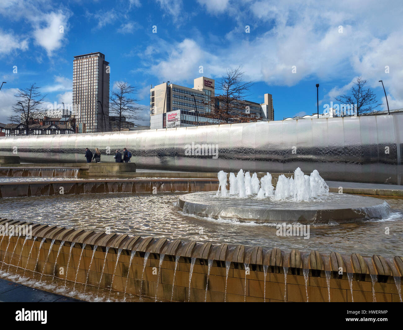 Fontana e il bordo di taglio di una scultura in un covone quadrato con hallam Univesity dietro Sheffield South Yorkshire Inghilterra Foto Stock