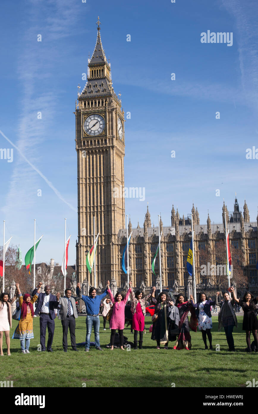 Persone di origini etniche tenendo le mani nella parte anteriore del Big Ben, Piazza del Parlamento, Westminster, London, Regno Unito Foto Stock