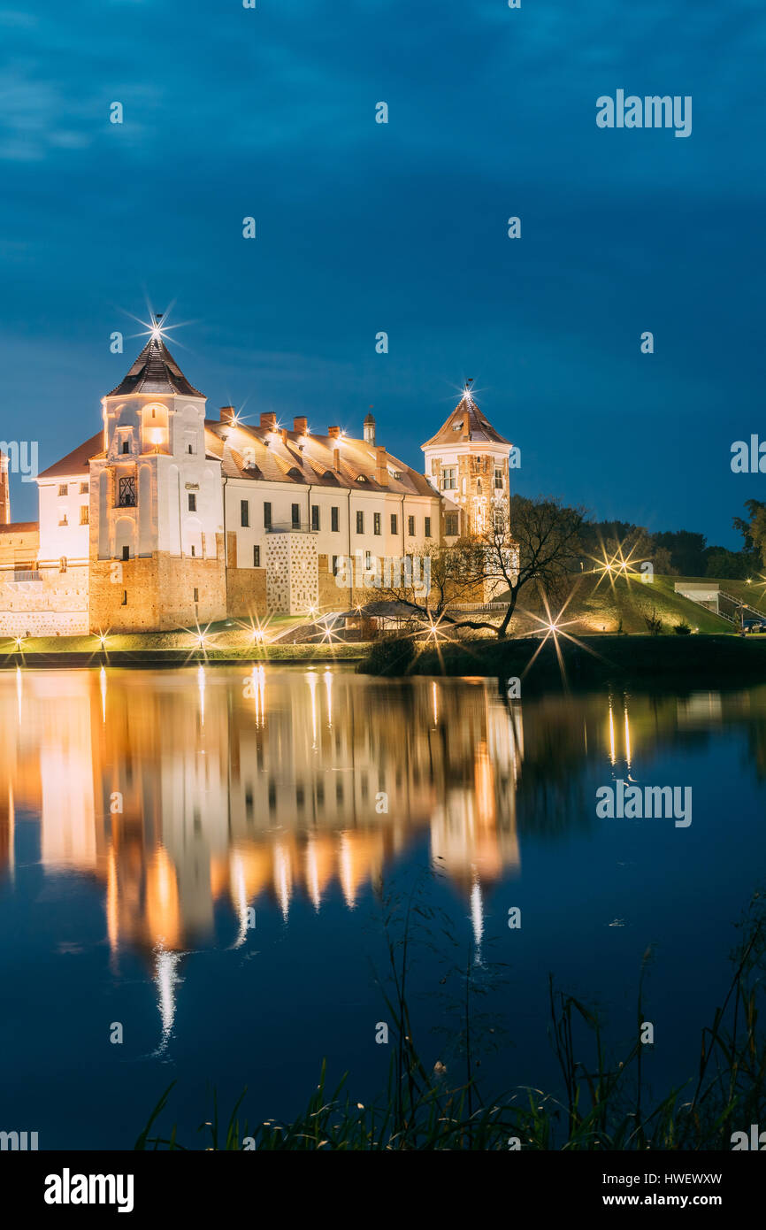 Mir, Bielorussia. Una vista pittoresca del complesso del Castello di Mir In brillante illuminazione serale con candelette di riflessioni sul lago di acqua. Famoso punto di riferimento, antica Gothi Foto Stock