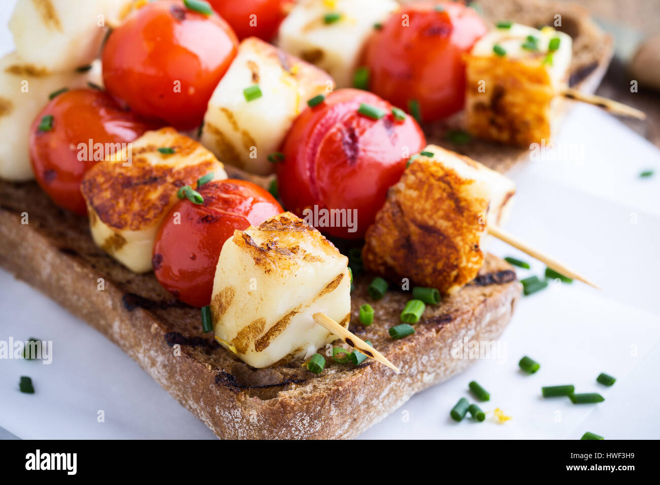 In casa aperta haloumi grigliate kebab panino con pomodoro e cipolla verde Foto Stock