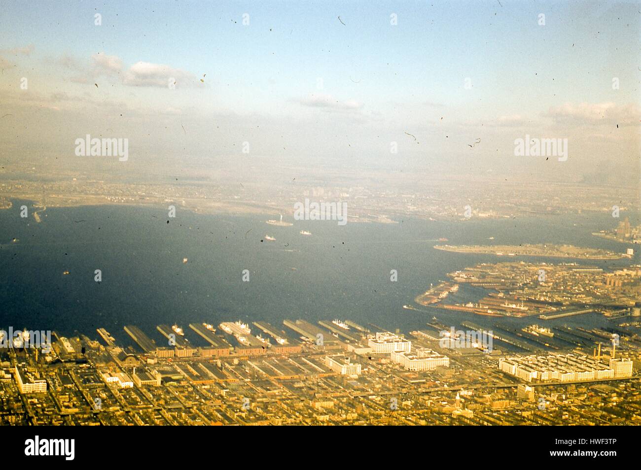 Vista aerea rivolta ad ovest da Sunset Park e Red Hook, Brooklyn, tra tomaia New York Bay per il New Jersey Shore del fiume Hudson, 1957. Al centro del porto è la Statua della Libertà e Ellis Island. Per il bordo destro è Governor's Island, appena oltre la punta del sud di Manhattan al Battery Park. Sullo sfondo il dock di Bayonne e la città di Jersey, New Jersey sono visibili per l'occidente. In primo piano a destra sono i bracci del bacino di Erie a Gowanus Bay Terminal in Red Hook, Brooklyn. Il terminale di Bush Company linea piloni sul lungomare al centro in primo piano. La Gowanus Express Foto Stock