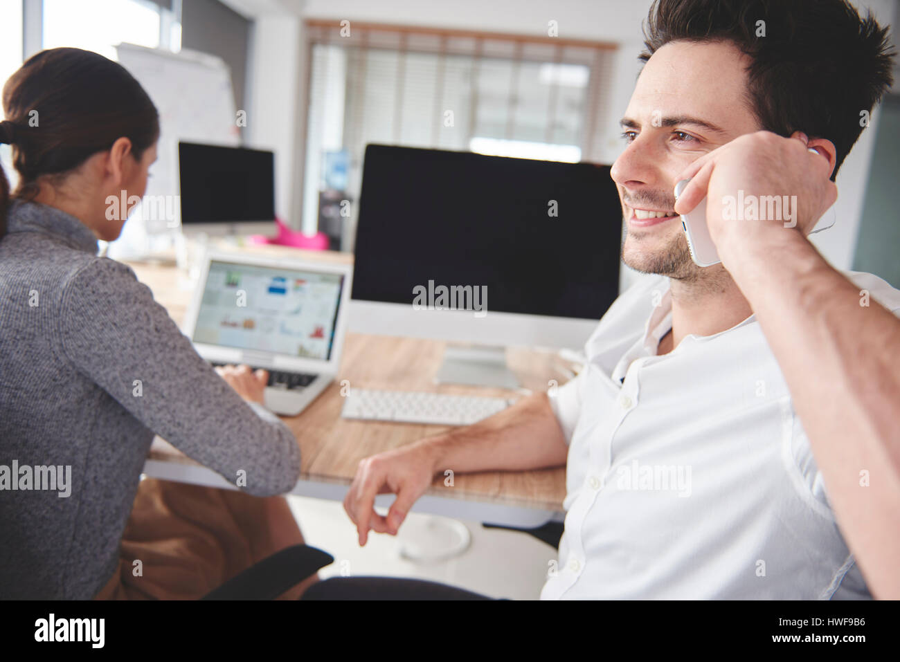 Azienda giovane usando la tecnologia wireless al lavoro Foto Stock