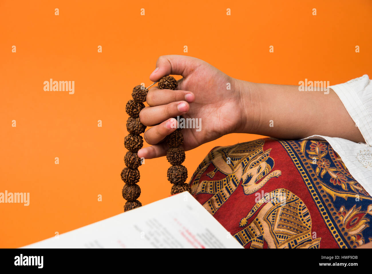 Primo piano immagine della mano mentre facendo meditazione con rudraksha mala o del rosario, la messa a fuoco selettiva Foto Stock