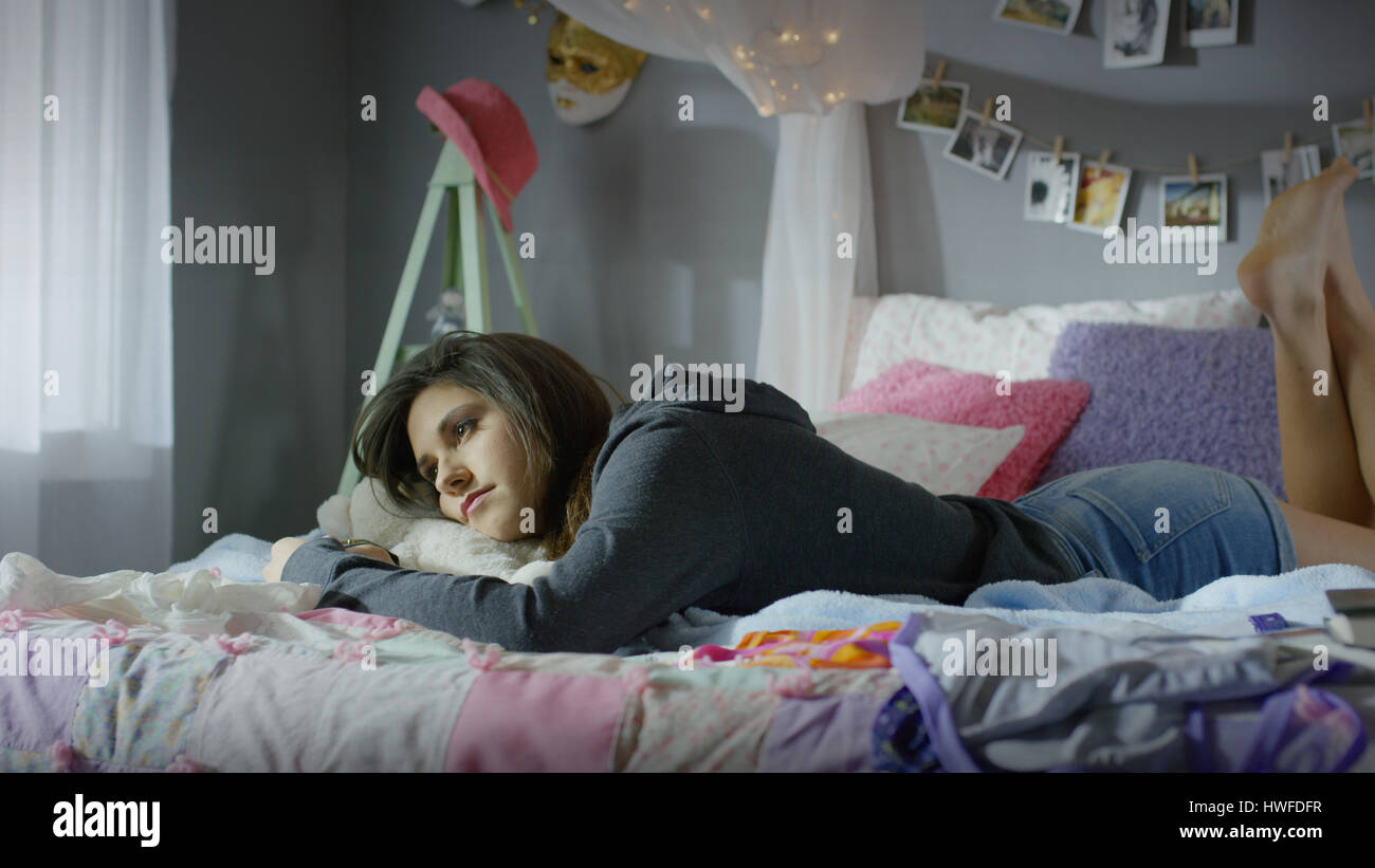 Malinconici ragazza adolescente posa sul letto Foto Stock