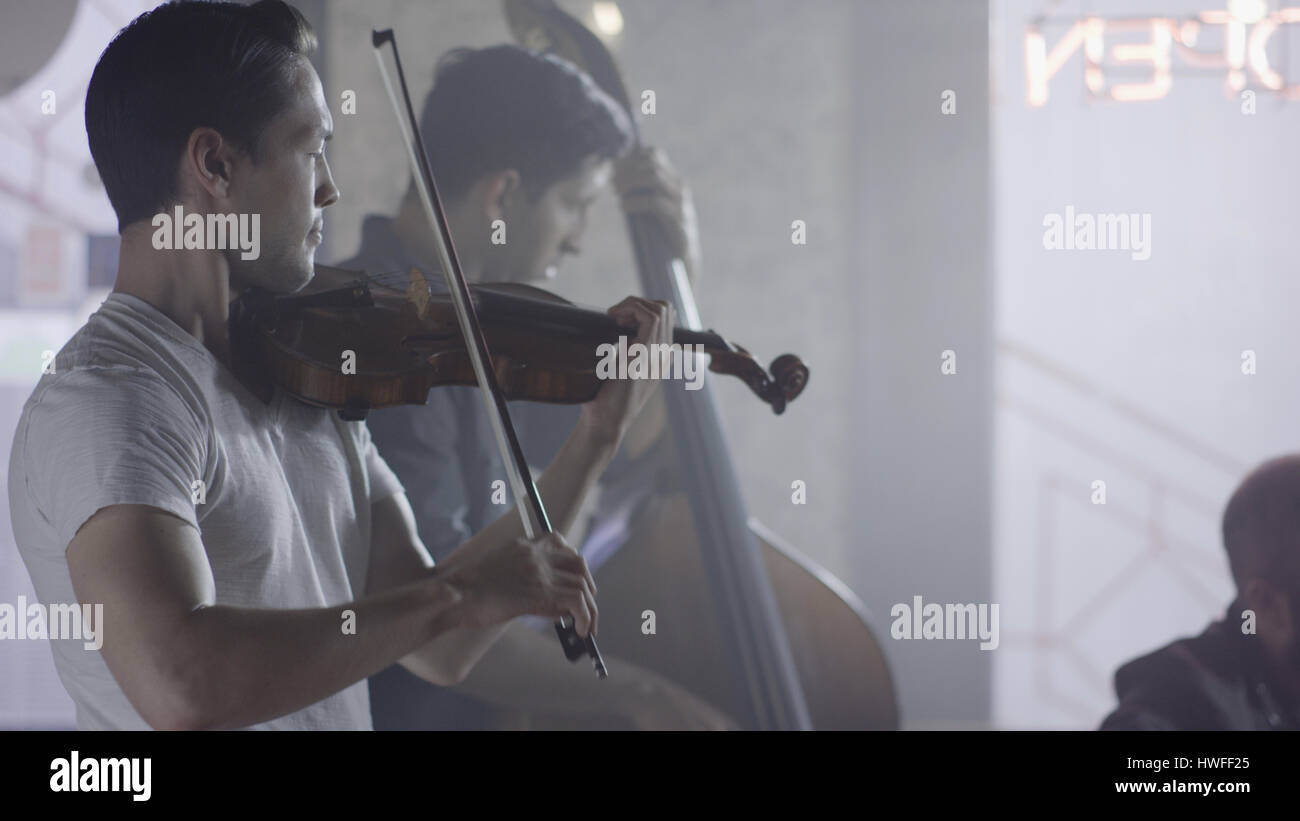 Grave il musicista suona il violino in banda nel cafe Foto Stock