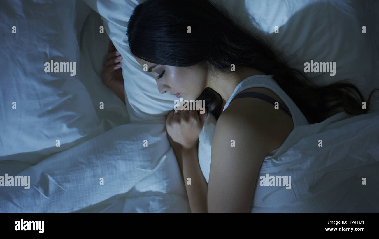Angolo di alta vista di profilo di donna addormentata che stabilisce nel letto Foto Stock