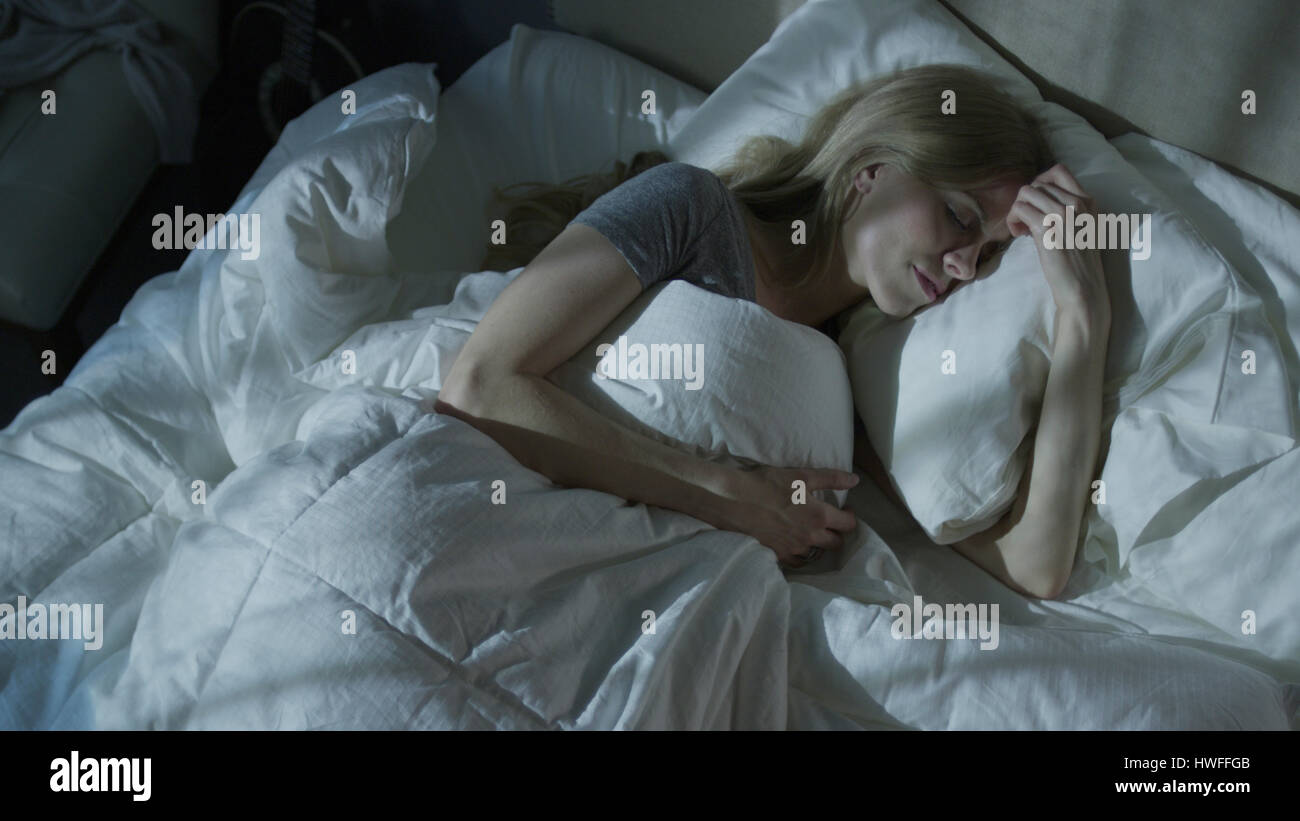 Elevato angolo di visione rilassata donna sogna e dormire sotto piumone nel letto Foto Stock