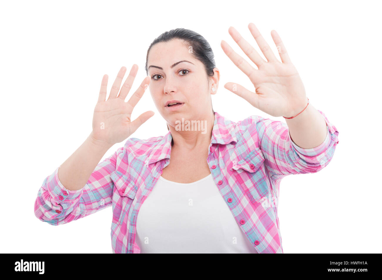 Spaventata donna sollevando in alto le mani in difesa come concetto di pericolo isolato su bianco Foto Stock
