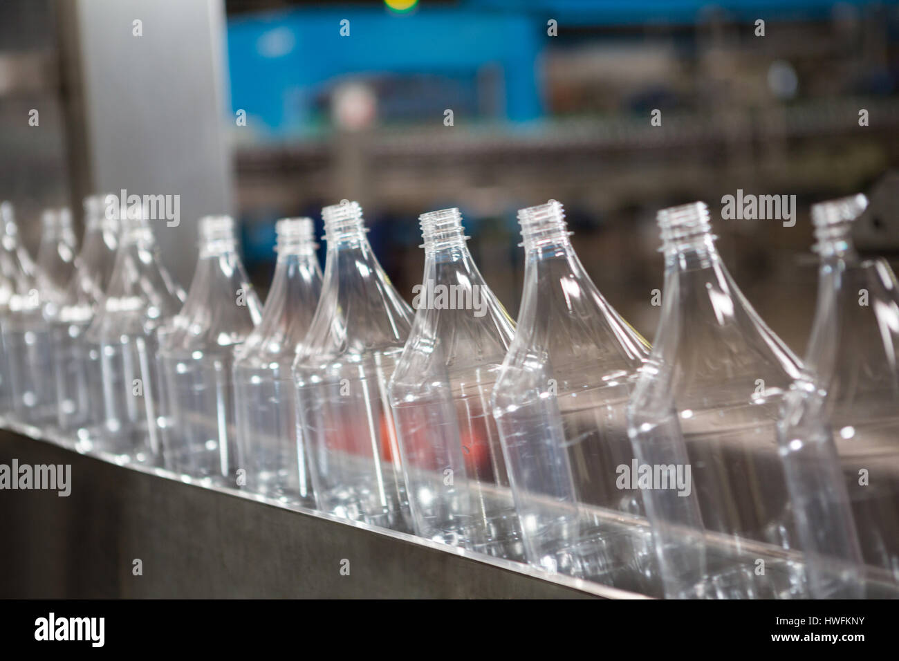 Fila di bottiglie vuote sulla linea di produzione nell'industria manifatturiera Foto Stock
