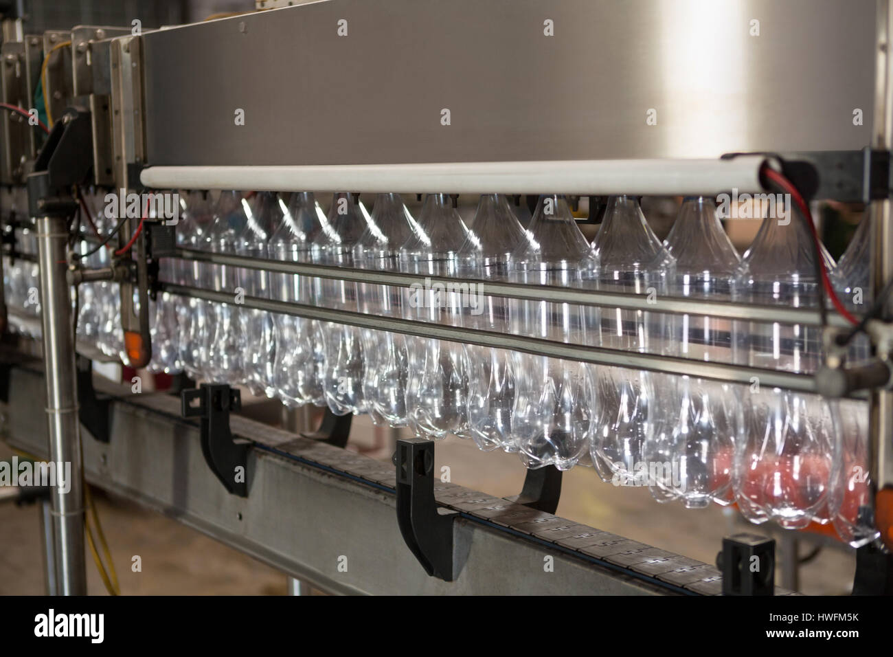 Fila di bottiglie vuote sulla linea di produzione in fabbrica di succo Foto Stock