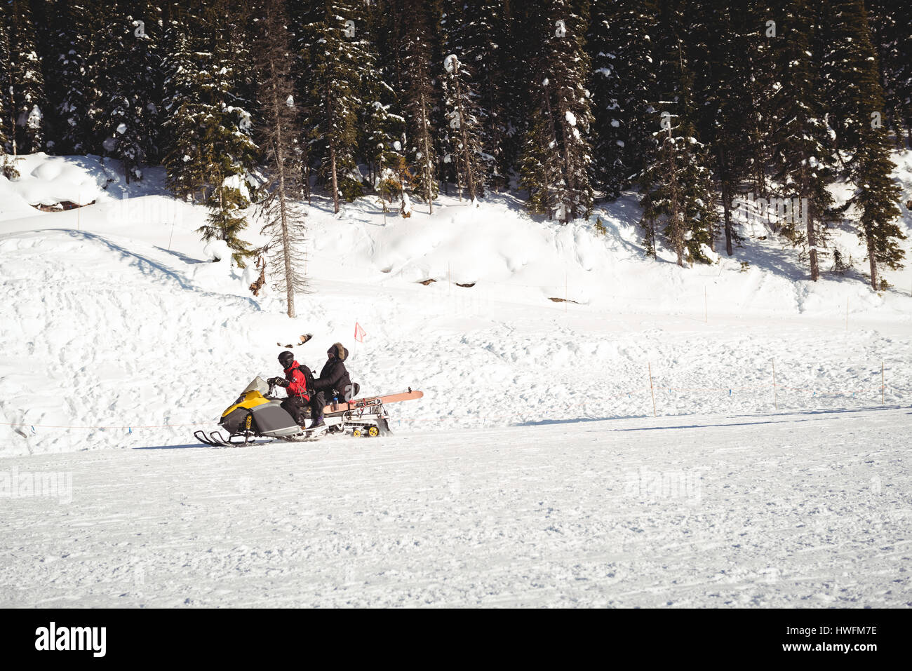 Gli sciatori equitazione motoslitta nelle Alpi innevate durante il periodo invernale Foto Stock