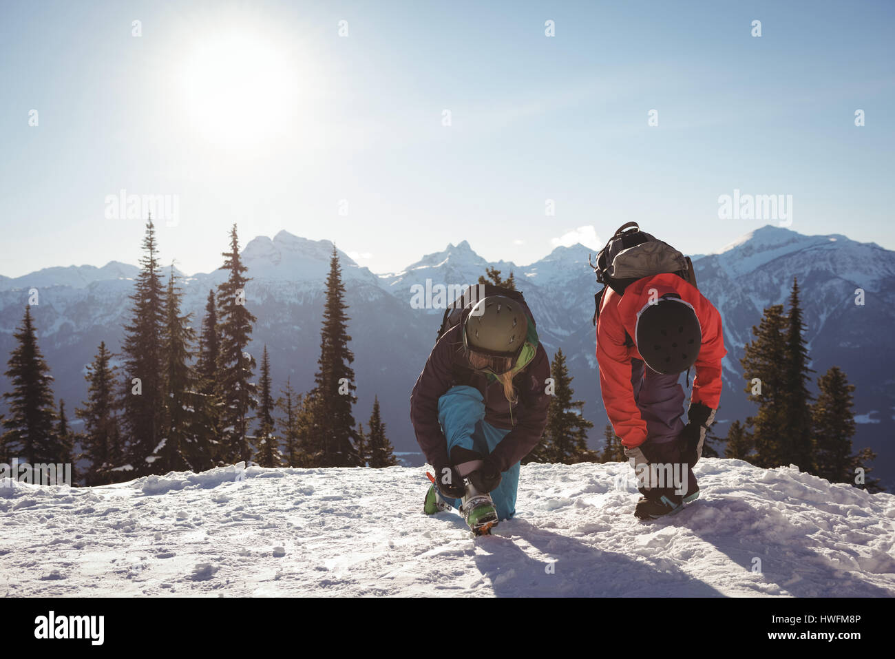Due sciatore la legatura i loro lacci delle scarpe su strade coperte di neve montagna durante l inverno Foto Stock