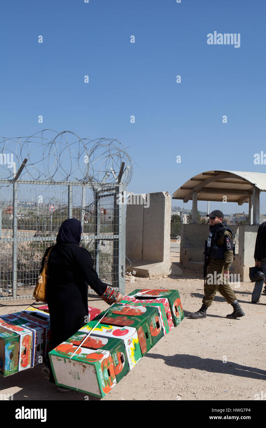 Donna palestinese e soldato al Checkpoint della barriera di separazione israeliano nei territori occupati Cisgiordania Medio Oriente Foto Stock