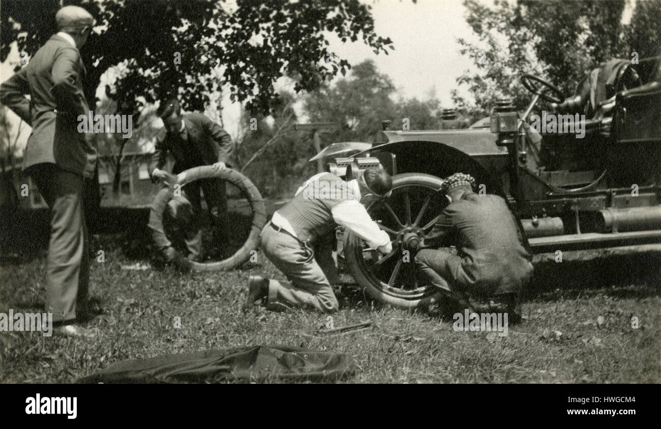 Antique c1905 fotografia, un gruppo di uomini cambiare un pneumatico sgonfio su un antico utilitaria auto. Posizione sconosciuta, probabilmente a New York. Vedere immagini di Alamy HWGCMD, HWGCKW e HWGCKR per visualizzazioni alternative di questa vettura. Fonte: originale stampa fotografica. Foto Stock