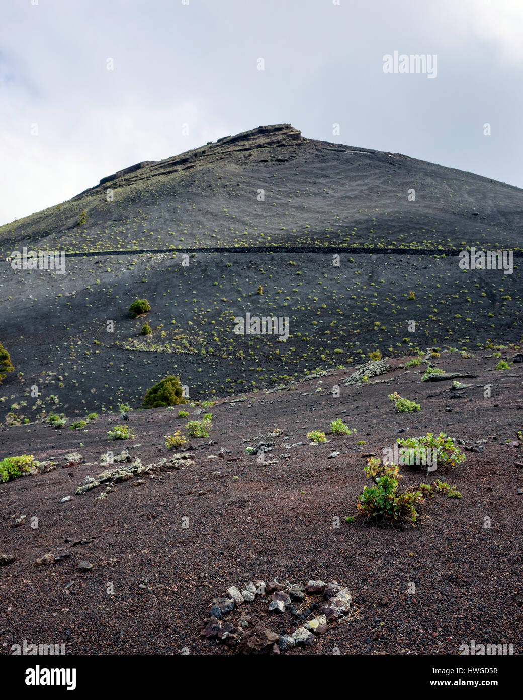 Volcan de San Antonio, Fuencaliente. La Palma. Una vista verso San Antonio vulcano. Il vulcano ha eruttato l'ultima nel 1677, che ha causato l'geologico formazione di terra e di roccia lavica paesaggio in cui la scarsa vegetazione è in grado di crescere. Nuvole indugiare oltre la cima del vulcano. Foto Stock