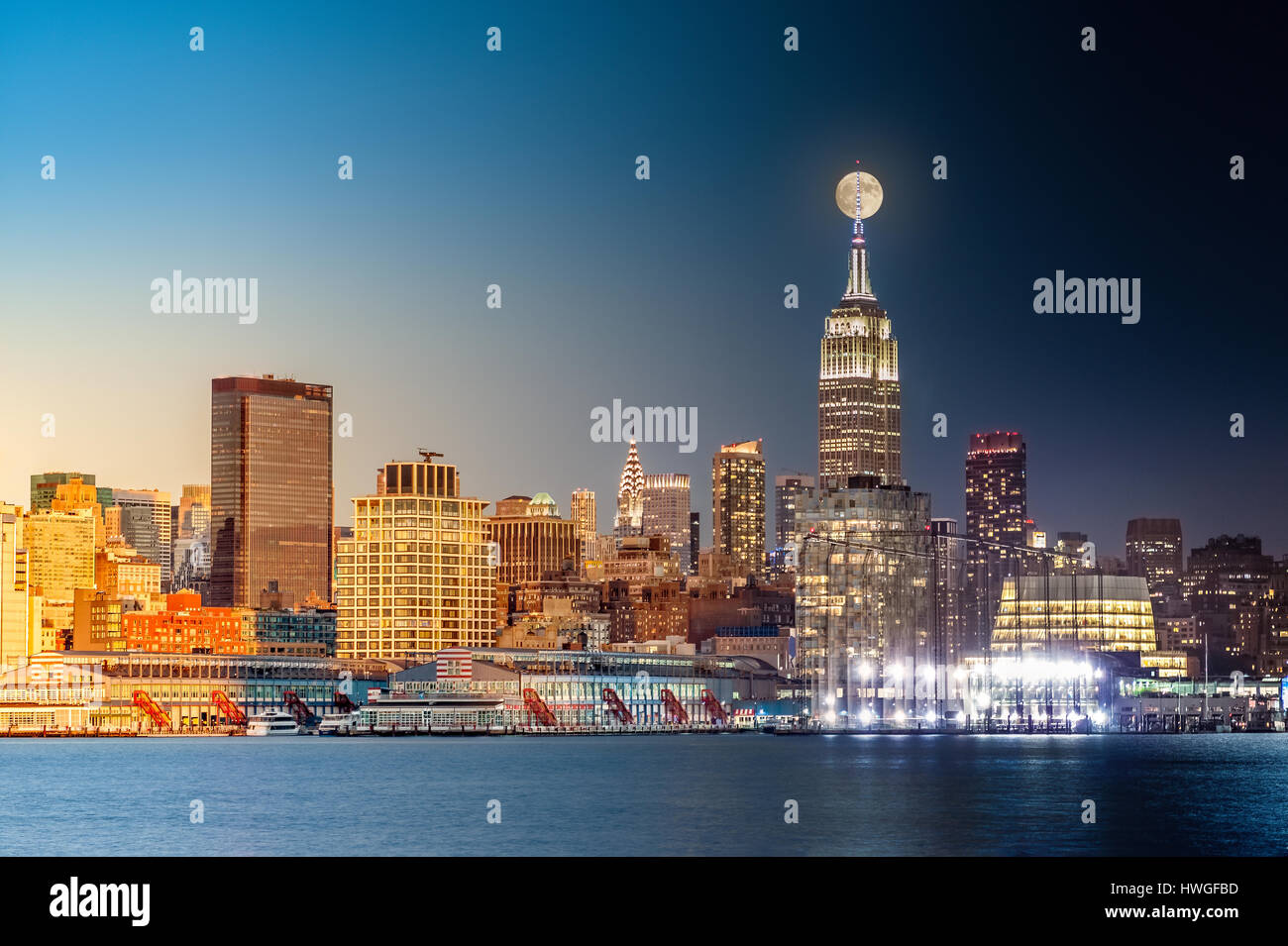 Composite giorno e notte il timelapse con la luna piena che si eleva al di sopra di New York skyline della citta'. Foto Stock