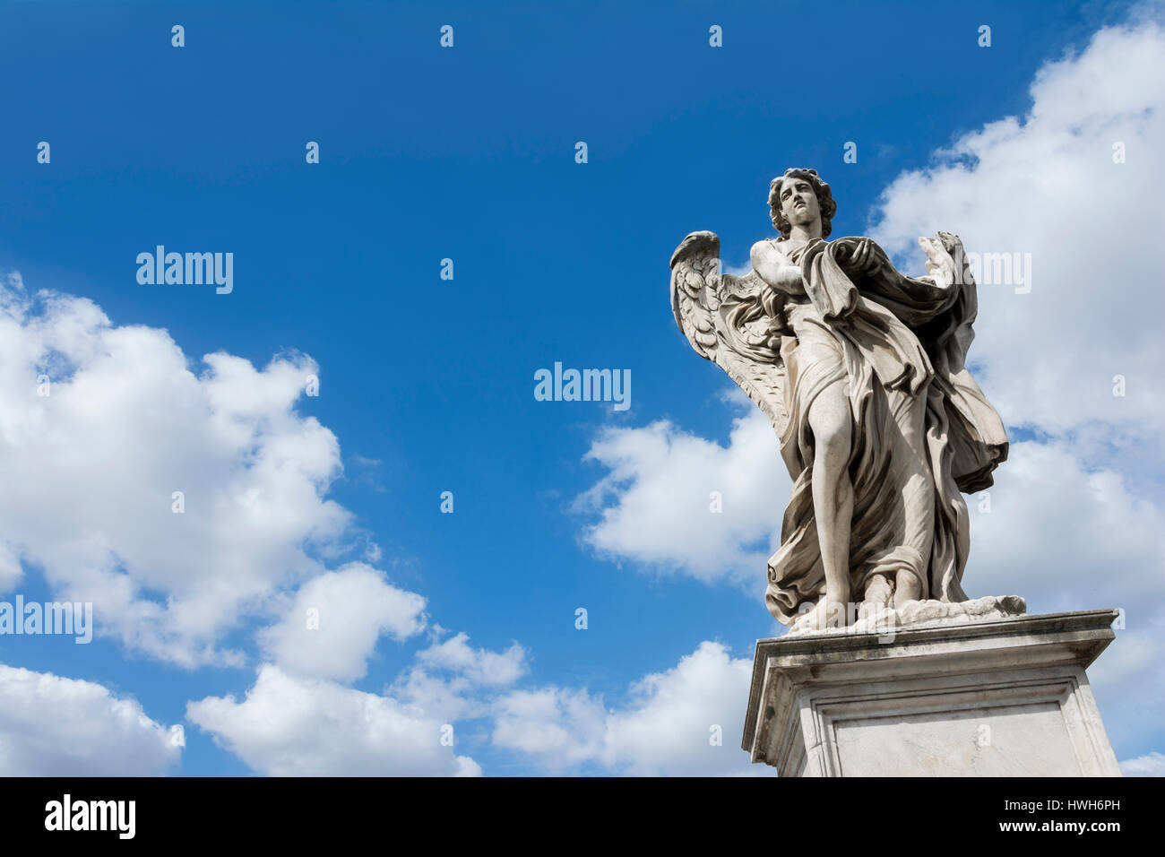 Angelo statua con vestito e piastrine su Castel Sant'Angelo Bridge, con celeste cielo e spazio di copia Foto Stock