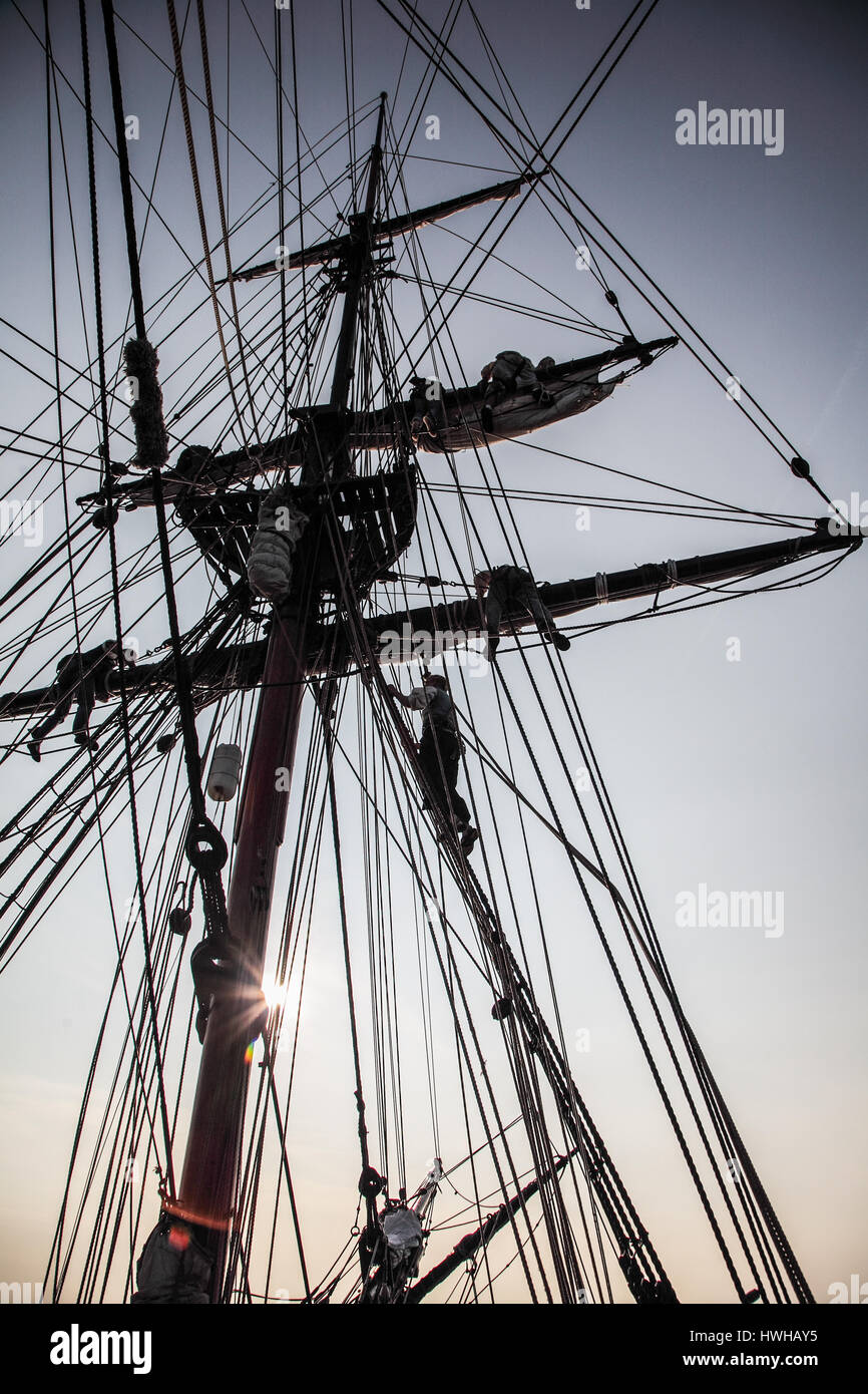 Una silhouette vista di Lady Washington equipaggio arrampicata corda Foto Stock