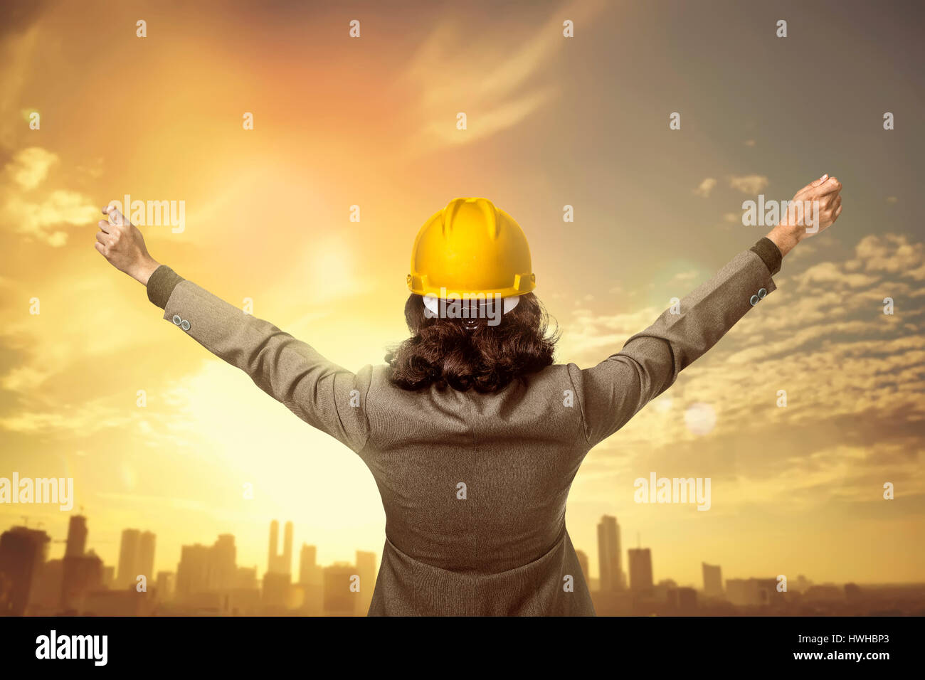 Vista posteriore architetto di alzare la mano guardando la città Foto Stock