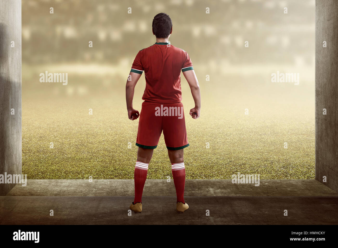 Vista posteriore di asian giocatore di football in piedi sul corridoio per il campo Foto Stock
