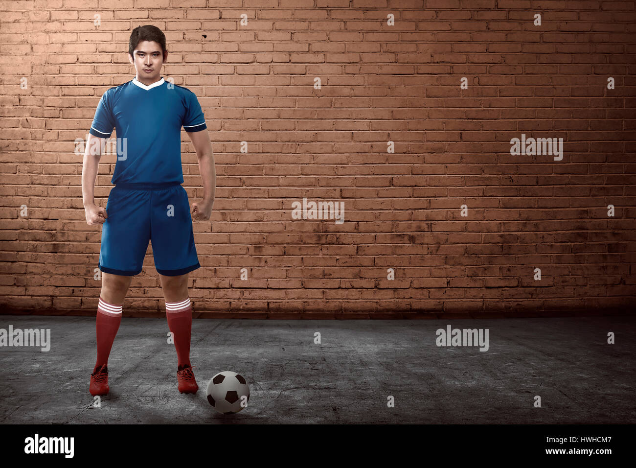 Asian giocatore di football in piedi sul vicolo pronto a giocare street soccer Foto Stock