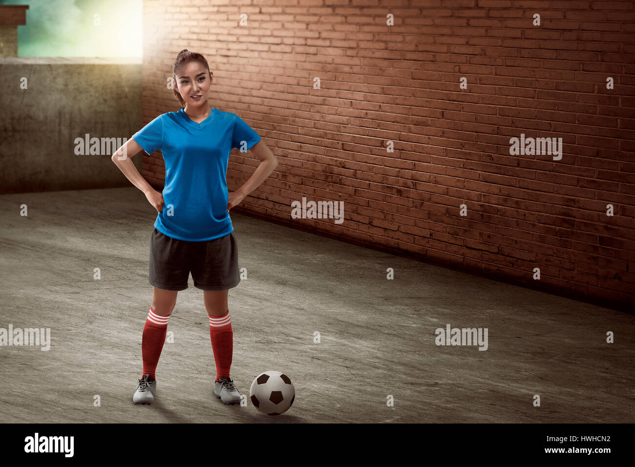 Immagine della femmina giovane giocatore di calcio in piedi sul vicolo Foto Stock