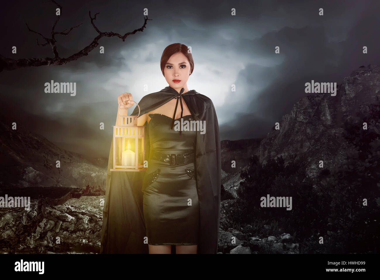 Asian strega donna con una lanterna camminando sulla collina della roccia Foto Stock