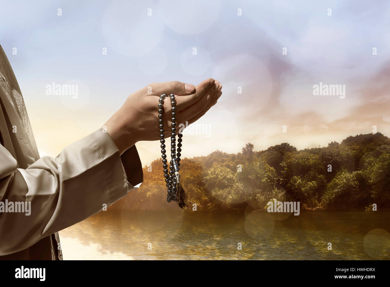 Canto del popolo musulmano di pregare con il lago sullo sfondo del paesaggio Foto Stock