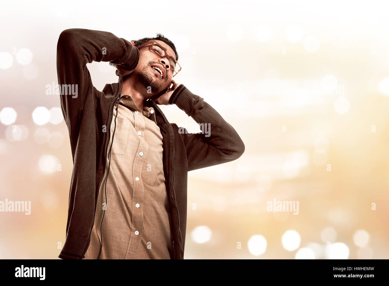 Immagine di asian giovane uomo ascoltare la musica tramite le cuffie Foto Stock