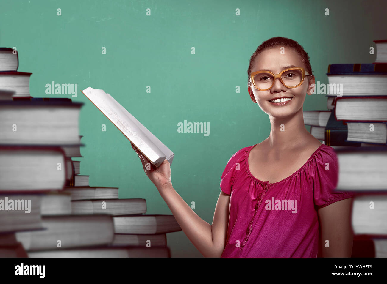 Immagine di asian studentessa azienda prenota con sfondo di libri Foto Stock