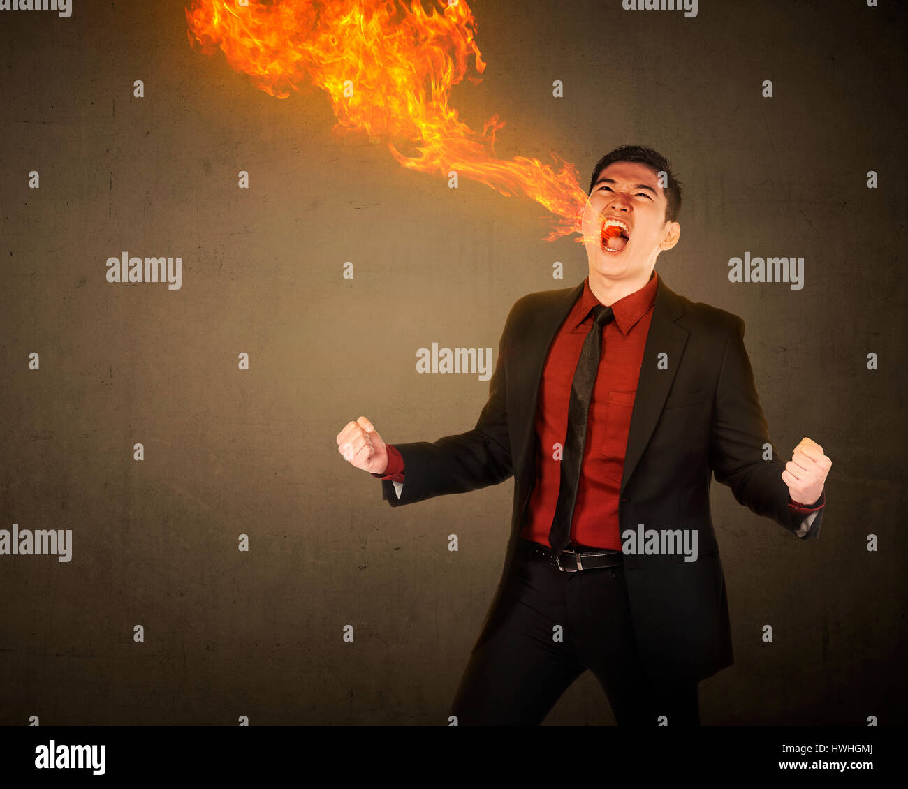 Business man avente fuoco respiro provenire dalla sua bocca Foto Stock