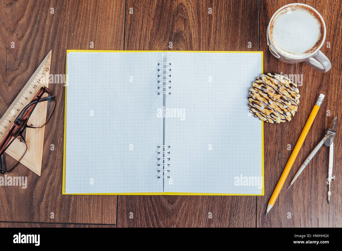 Vista superiore del notebook, cancelleria, strumenti di disegno e un paio di tazze di caffè Foto Stock