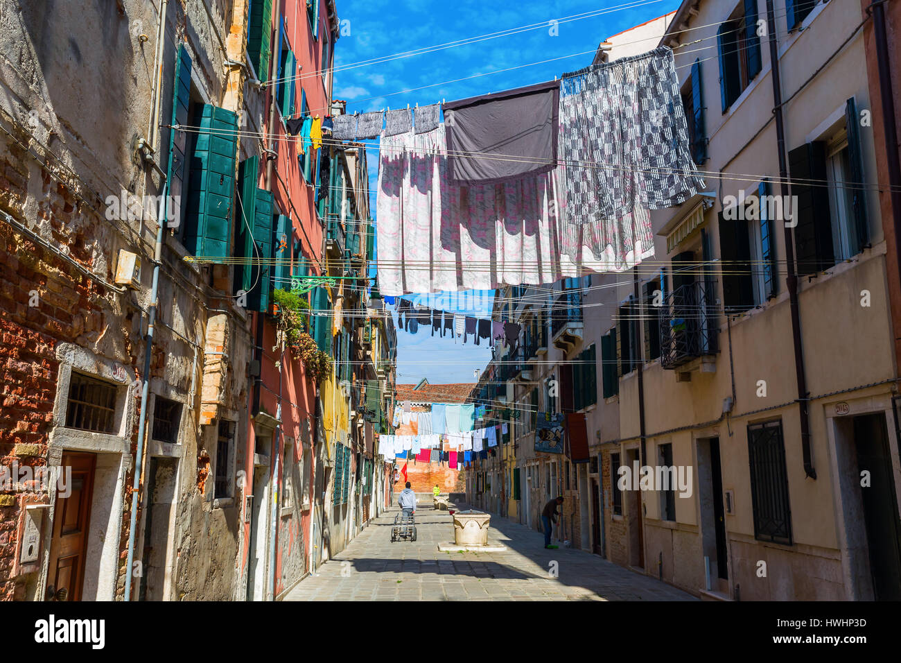 Venezia, Italia - 27 Febbraio 2017: tipico vicolo con clotheslines e persone non identificate. Venezia è conosciuta in tutto il mondo per la bellezza delle sue impostazioni, un p Foto Stock