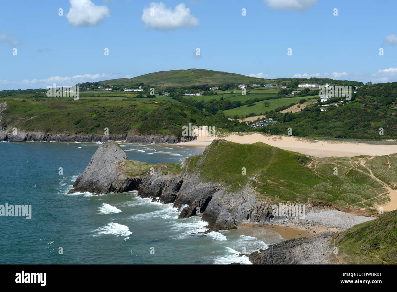 Tre scogli, Pobbles spiaggia con cefyn bryn e Penmaen situato nella bellissima costa gallese all'orizzonte Foto Stock