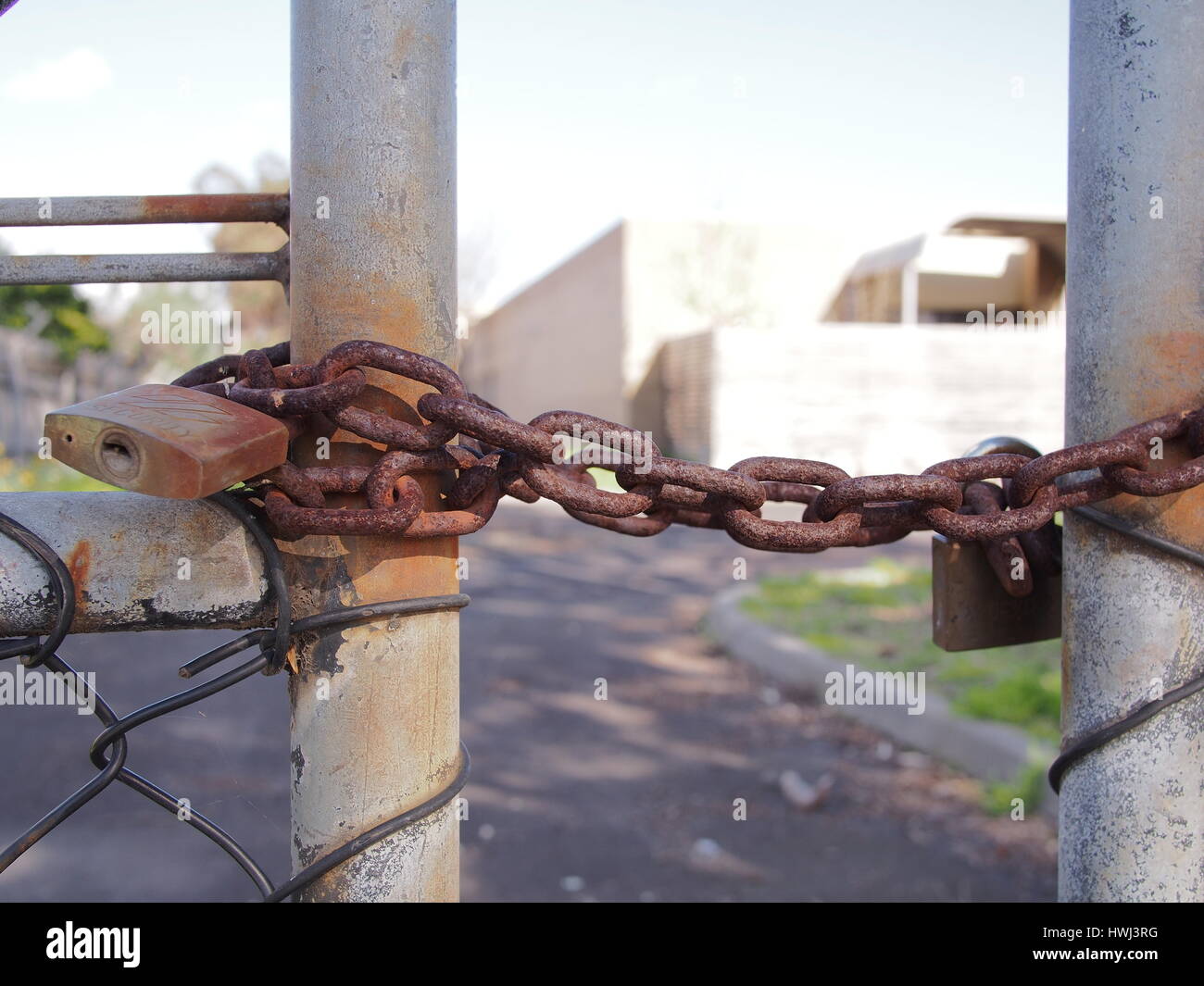 Melbourne, Australia - 4 Agosto 2016: Bloccare sul filo di una recinzione di sicurezza a fronte di un industriale edificio di stile Foto Stock