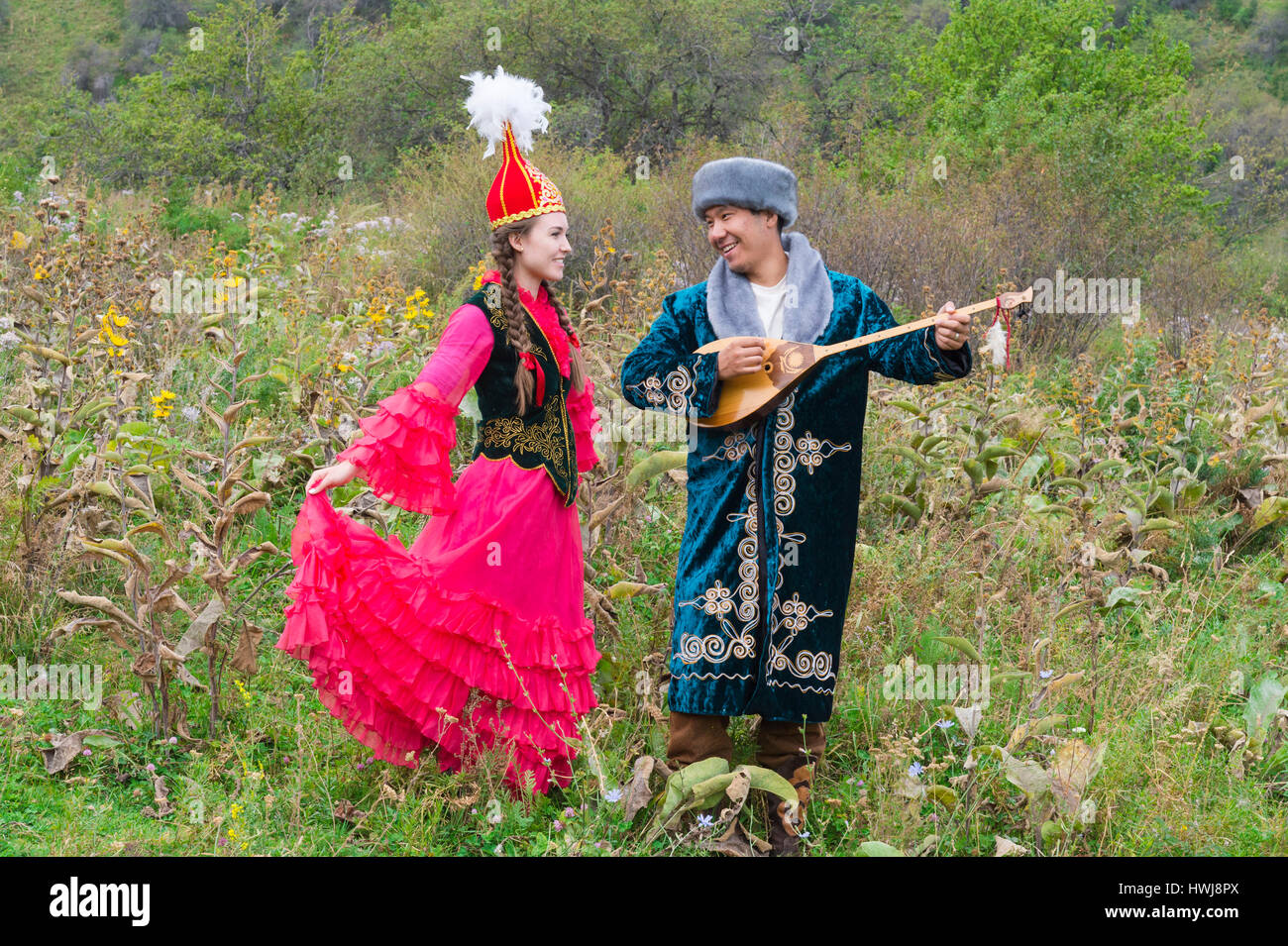 Uomo kazako suonando e cantando dombra per una donna, il kazako villaggio etnografico Aul Gunny, Talgar città, Almaty in Kazakistan e in Asia centrale, per il solo uso editoriale Foto Stock