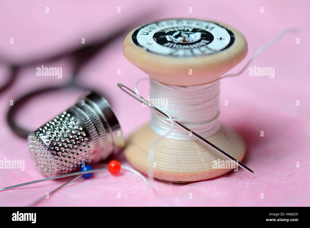 Ditale, ago di cucitura e bobina di cotone Foto Stock