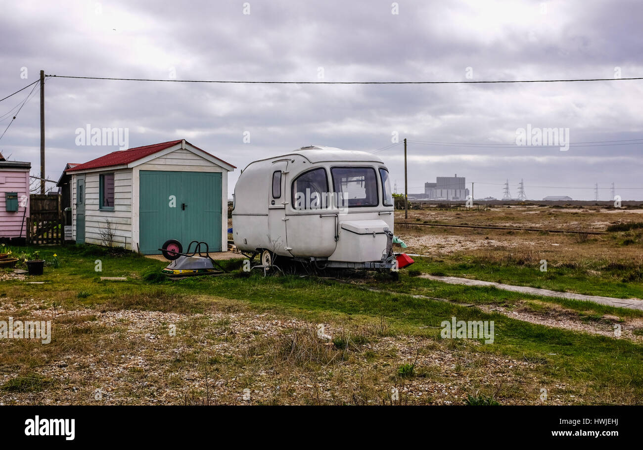 Vecchia roulotte e bungalow sulla giornata uggiosa a Dungeness Kent REGNO UNITO fotografia scattata da Simon Dack Foto Stock