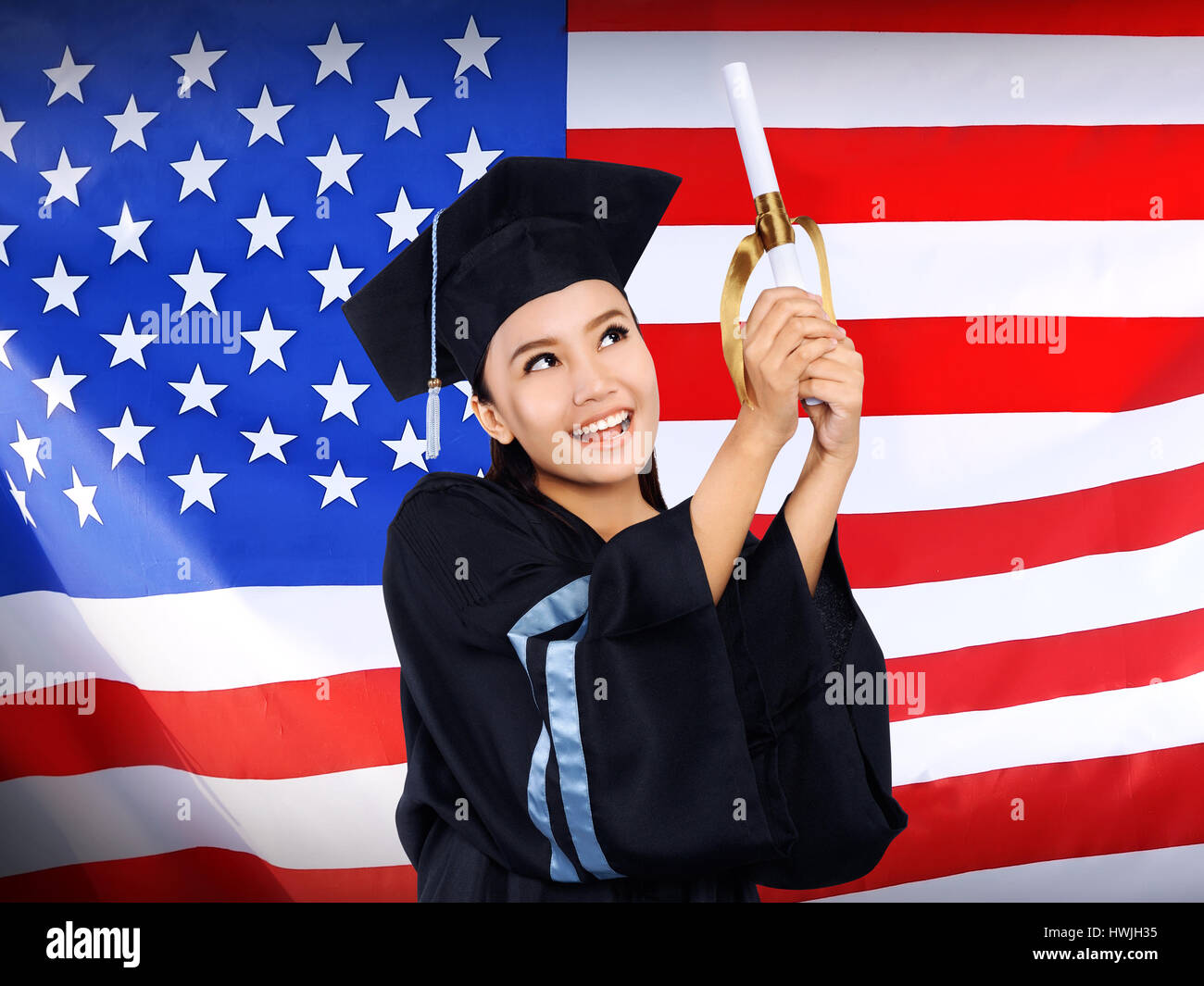 Felice femmina studente asiatico con bandiera degli Stati Uniti sullo sfondo. Studiare in USA concettuale Foto Stock