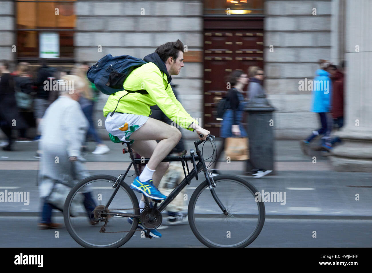 Ciclista maschio in bicicletta lungo oconnell street a Dublino Repubblica di Irlanda deliberata di sfocatura del movimento Foto Stock